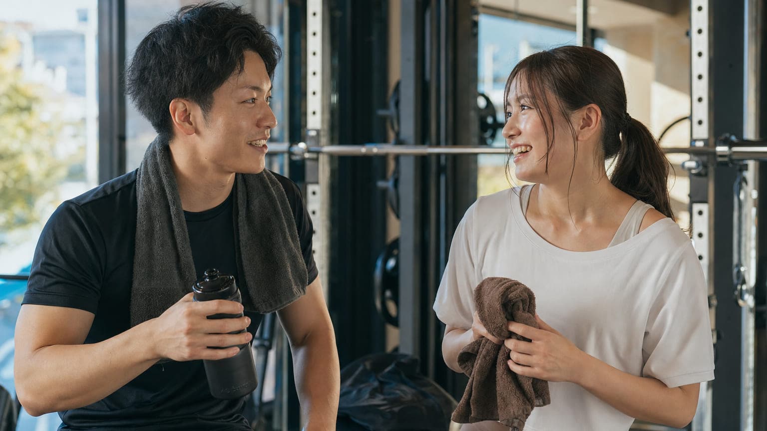 セッションを終えてジムのフロアで和やかに話すトレーナーとクライアント